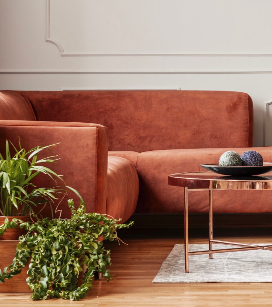Stylish copper colored coffee table in front of comfortable corner sofa in trendy living room